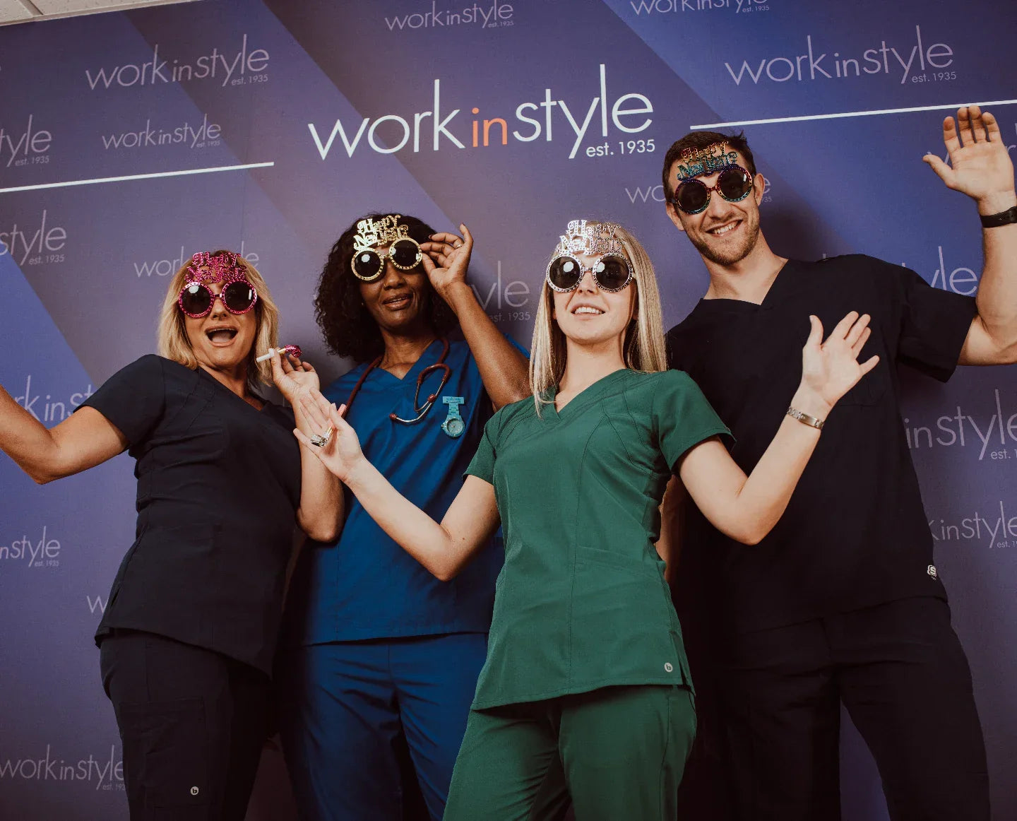 Group of healthcare professionals in colorful medical scrubs celebrating with party glasses