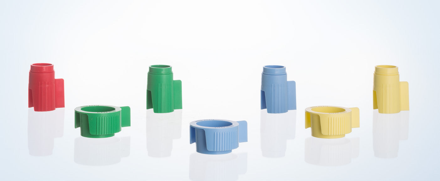Colorful plastic medical caps and connectors for healthcare supplies on white background