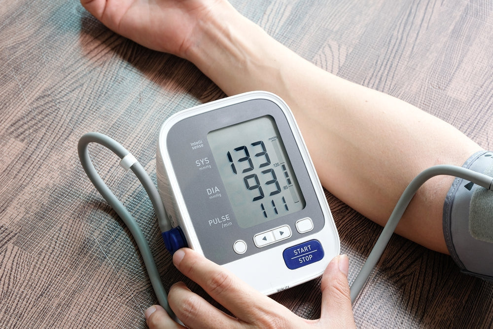 Digital blood pressure monitor checking blood pressure on a person's arm