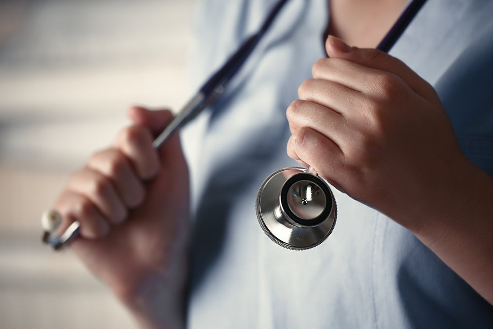 Healthcare professional holding stethoscope, medical diagnostic equipment close-up
