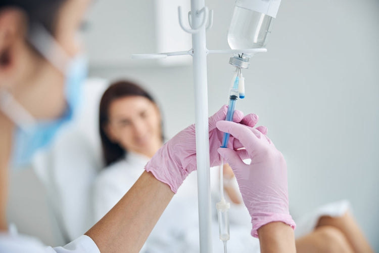 Nurse in gloves preparing IV drip for patient in medical clinic