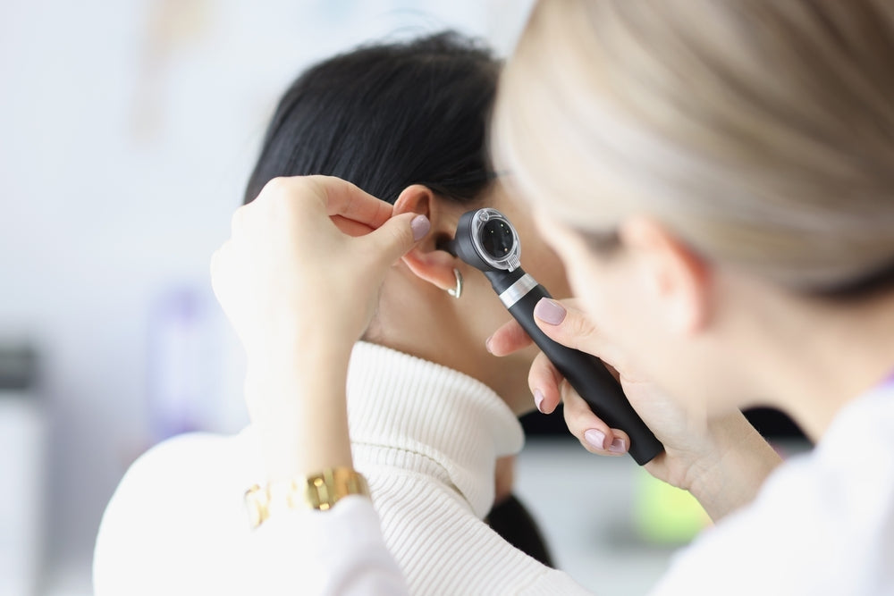 Doctor using otoscope for ear examination on patient in medical clinic