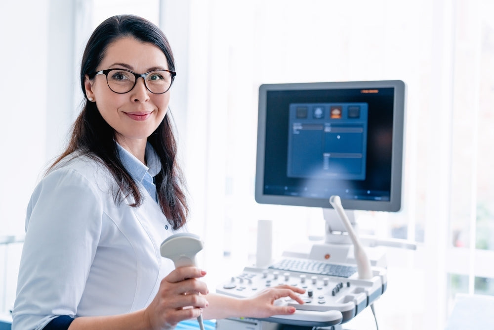 Female healthcare professional operating ultrasound machine in bright clinic