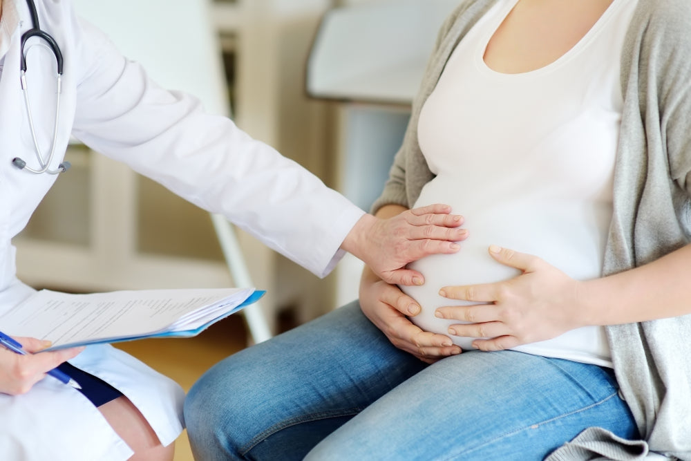 Doctor examining pregnant woman during gynecology consultation in clinic