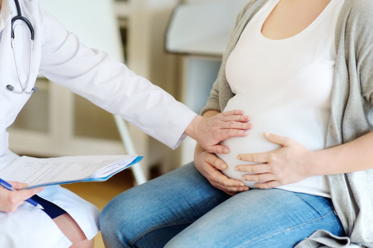 Doctor examining pregnant woman during gynecology consultation in clinic