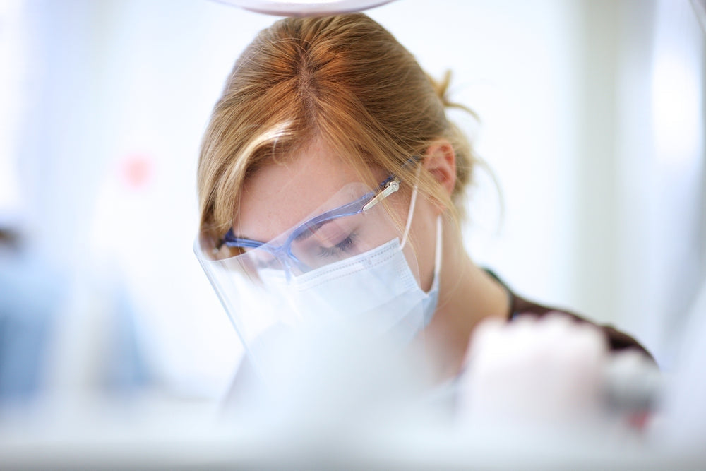 Healthcare worker wearing face mask, safety goggles, and face shield for infection control