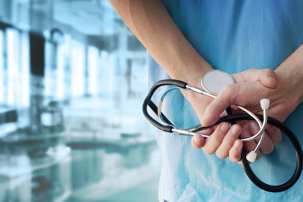 Doctor holding a stethoscope in a modern medical clinic background