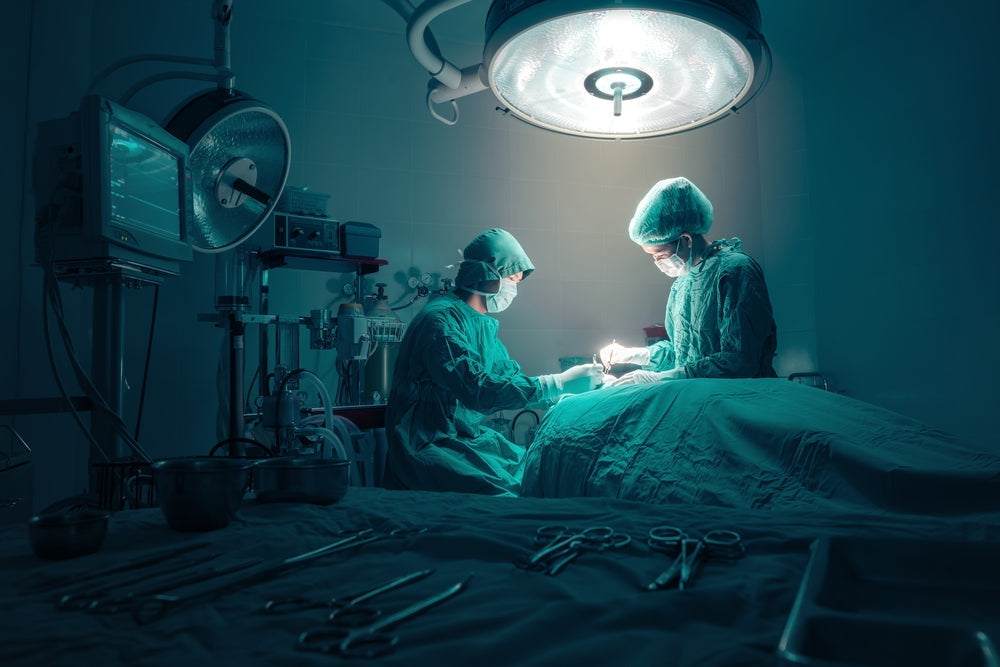 Surgeons performing operation in sterile hospital operating room with surgical instruments