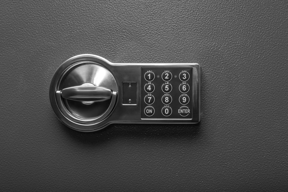 Electronic lock box with digital keypad and secure turn handle on a textured black surface