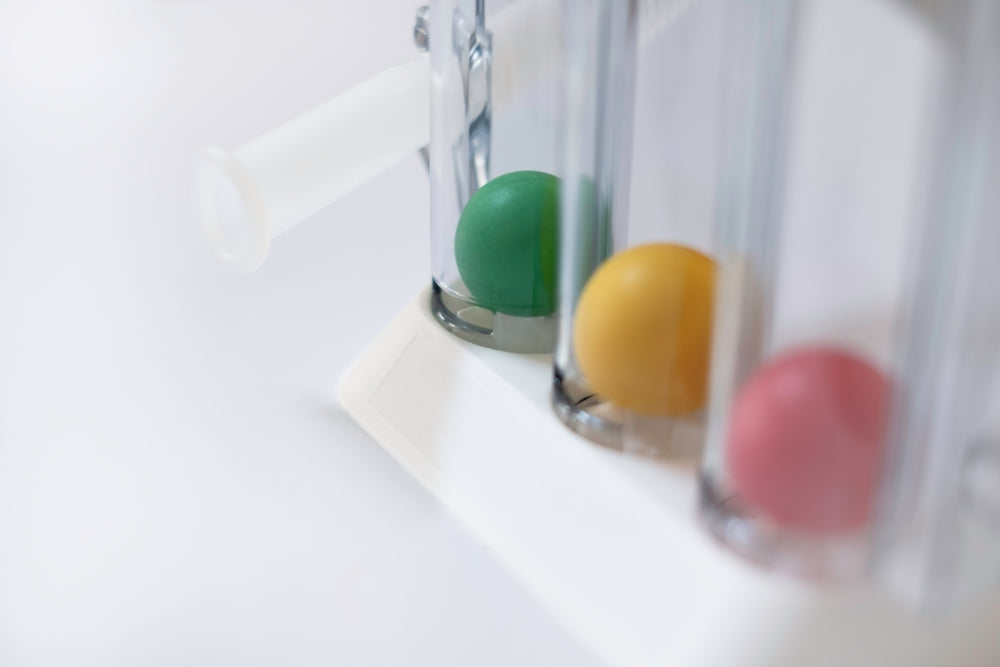 Spirometer device with green, yellow, and pink balls for respiratory therapy