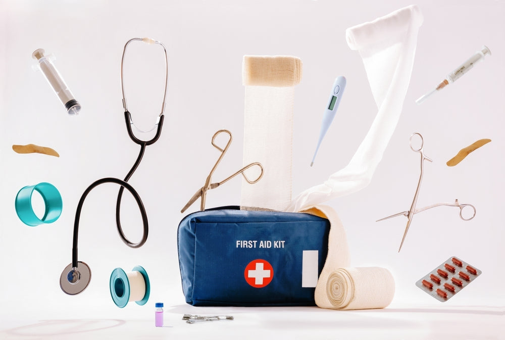 Medical first aid kit with stethoscope, bandages, syringe, scissors, thermometer and supplies