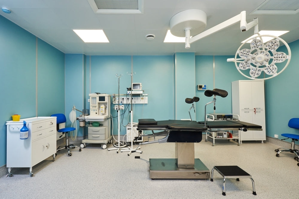 Modern surgical room with blue walls, medical equipment, operating table, and cabinets