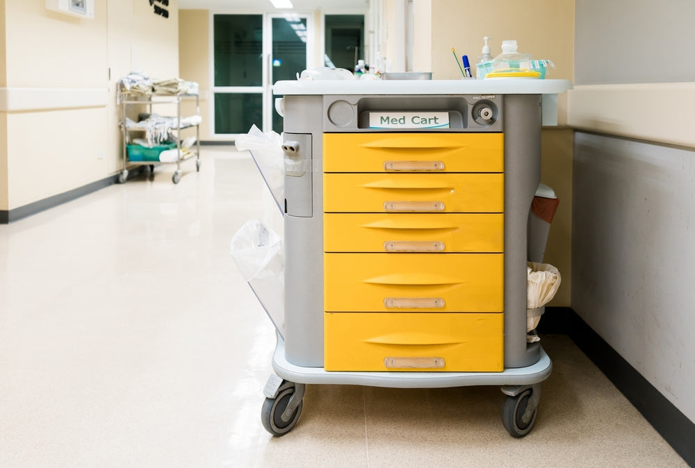 Yellow medical trolley cart with supplies in a hospital corridor setting