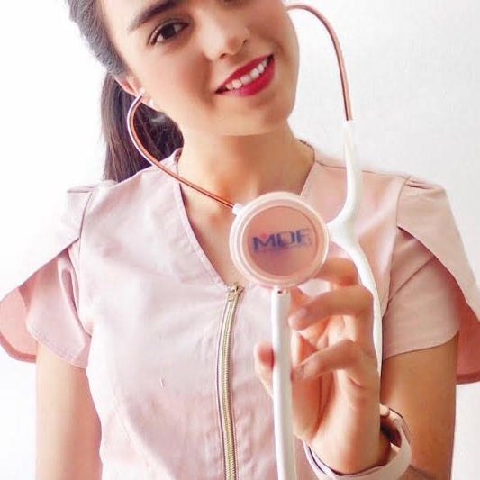 MDF Instruments Acoustica® Stethoscope in white with rose gold accents, shown in a lifestyle setting.